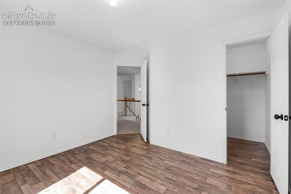 Image 31 of 48: Wood-finish flooring with white walls and trim