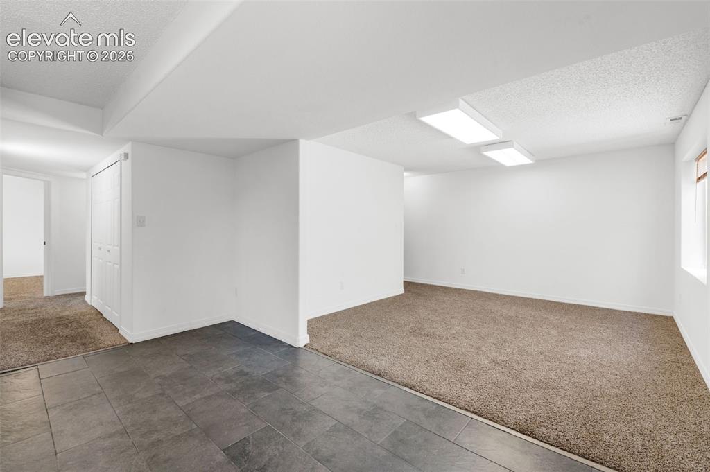 Image 34 of 48: Spacious room featuring broadloom carpeting, recessed lighting, and a windo