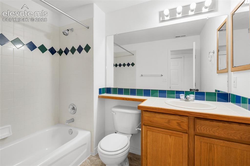 Image 39 of 48: White ceramic tile shower surround with decorative accent tiles