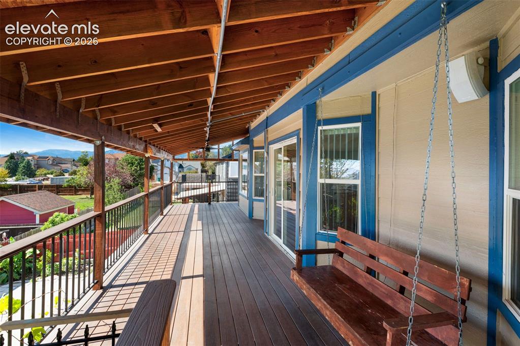 Image 48 of 48: Expansive covered deck with composite decking and exposed wood ceiling beam