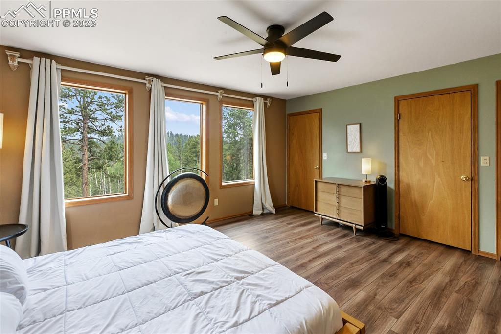Image 20 of 50: Primary bedroom has so much natural light and looks out to the views.