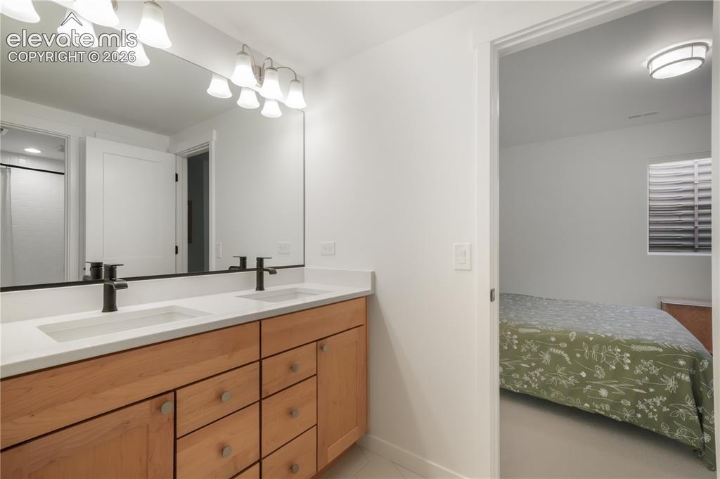 Image 43 of 50: Dual vanity, tile flooring and shower/tub