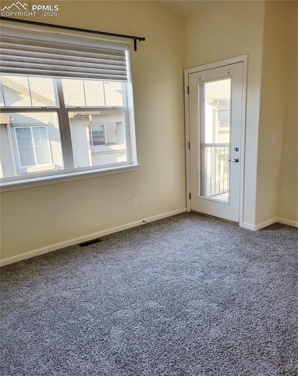 Image 22 of 38: Large primary bedroom upstairs with walk out to balcony patio.