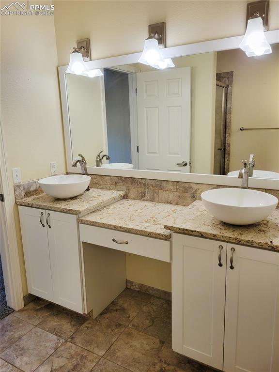 Image 25 of 38: Gorgeous primary bathroom w/ double vanities and lovely walk-in tile shower