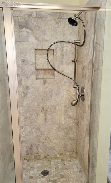 Image 26 of 38: Beautifully tiled walk-in shower in primary bathroom.
