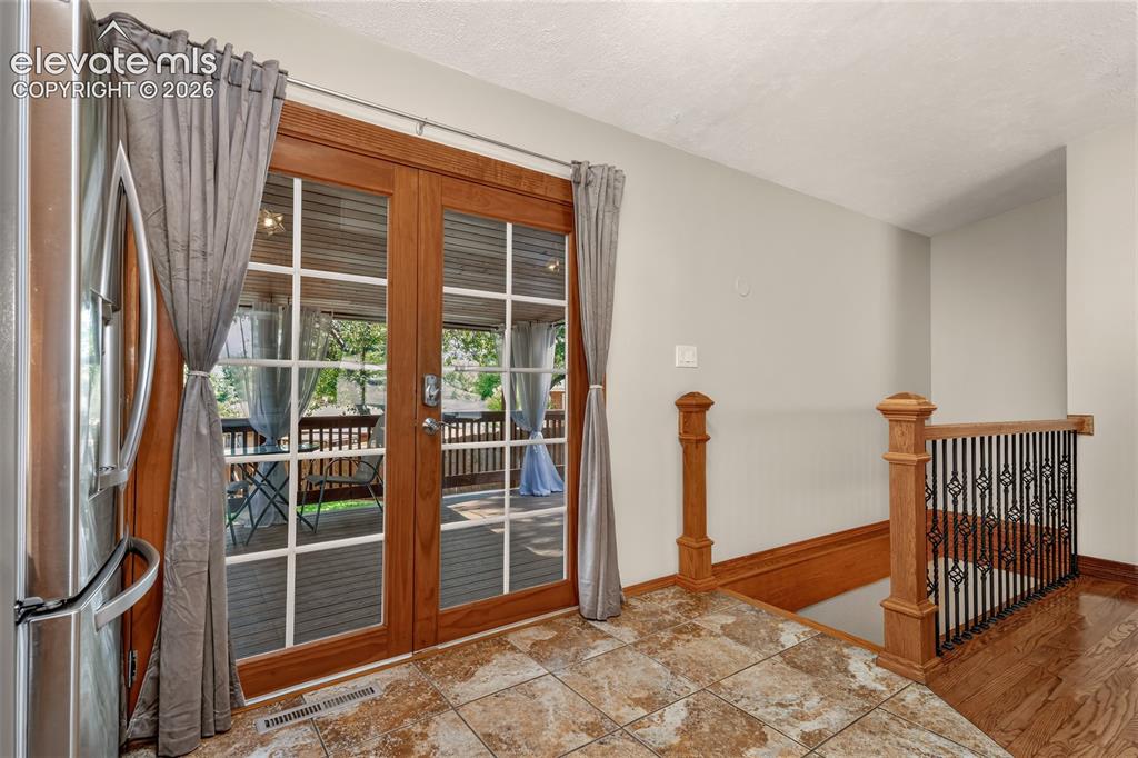 Image 12 of 36: Walkout to back deck and backyard and stairs down to the basement.
