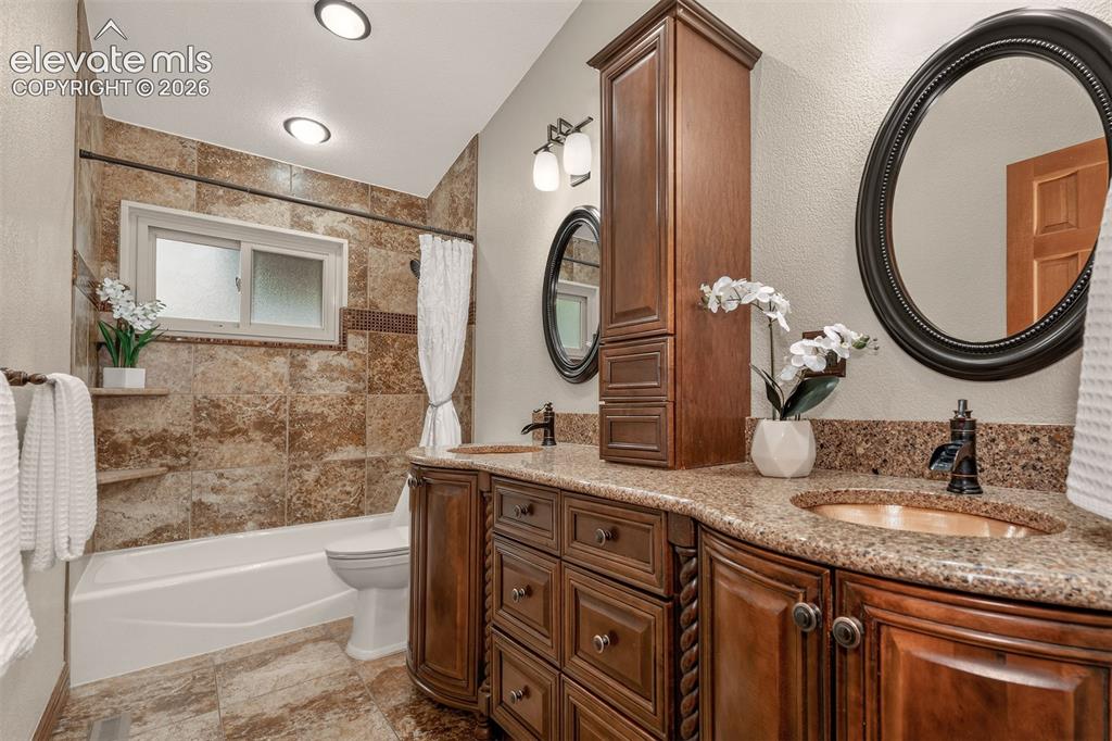 Image 19 of 36: Main level bathroom with dual sinks and granite countertops.