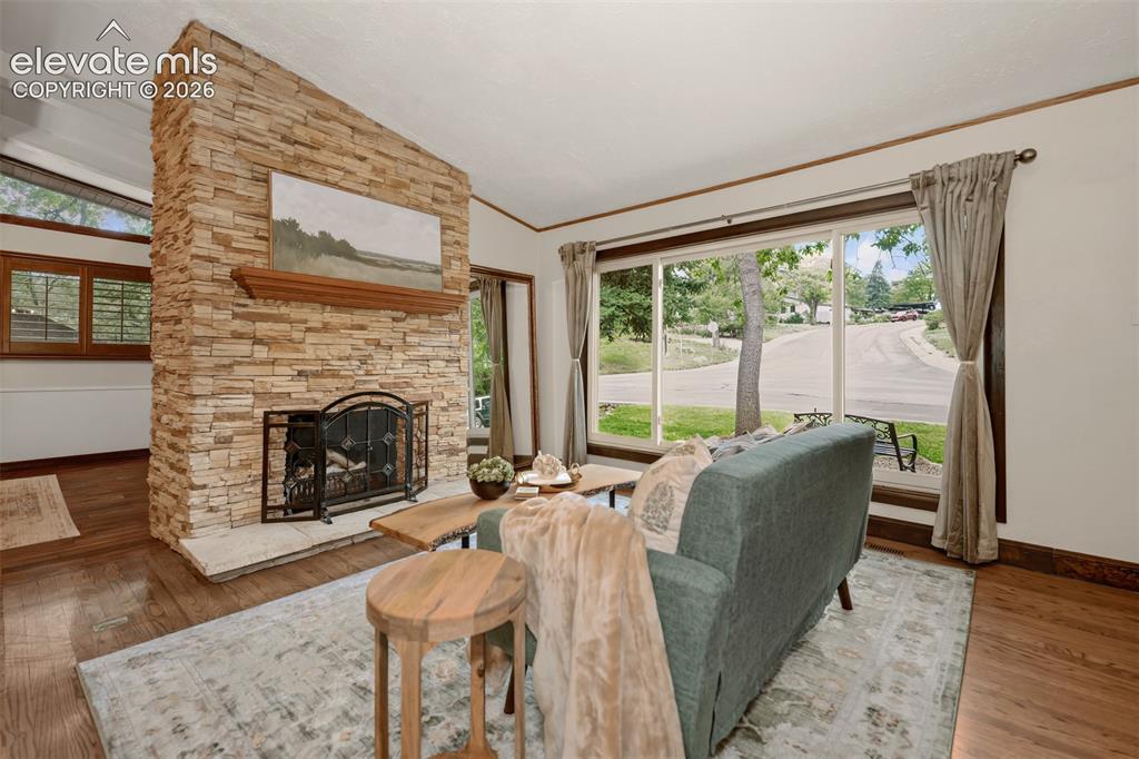 Image 5 of 36: Beautiful living room with large picture window, hardwood floors and firepl