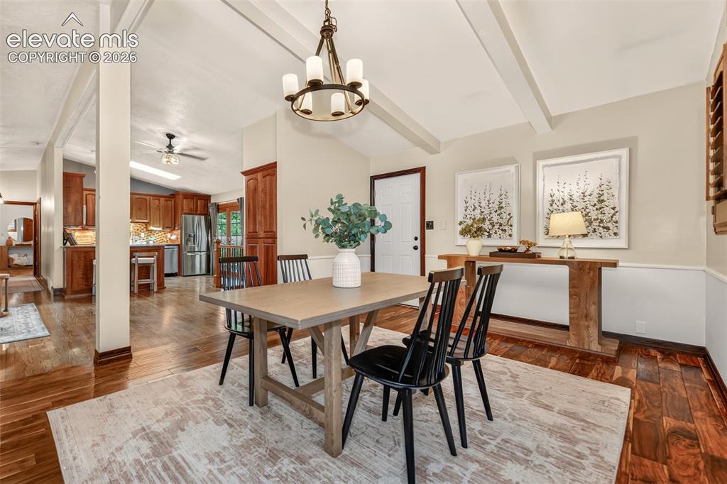 Image 8 of 36: Dining area with hardwood flooring, opening to the living room with a walko