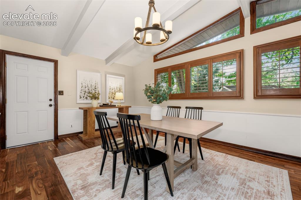 Image 9 of 36: Dining area with vaulted ceiling, hardwood floors and a walkout to the back