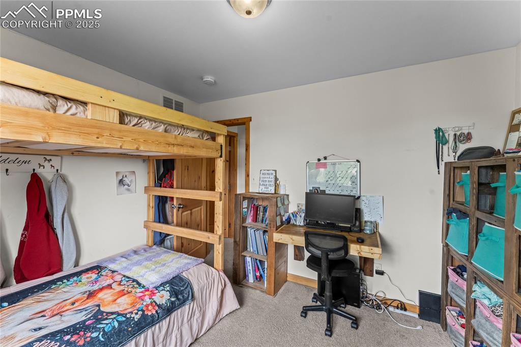 Image 24 of 30: Bedroom featuring carpet floors and a desk