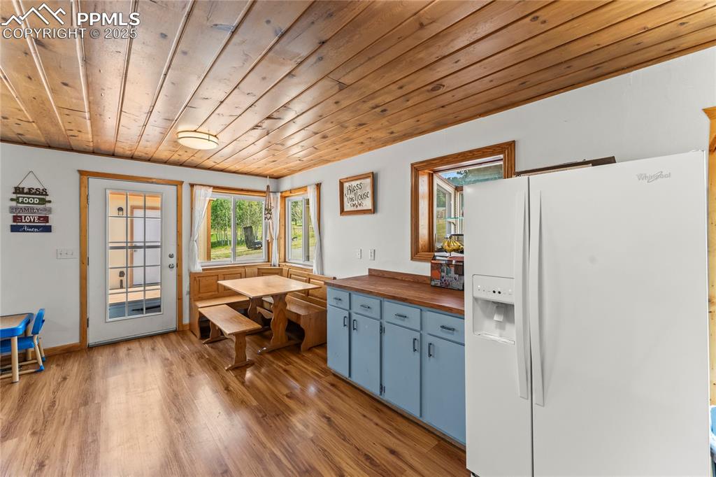 Image 9 of 30: Kitchen with butcher block countertops, white fridge with ice dispenser, wo