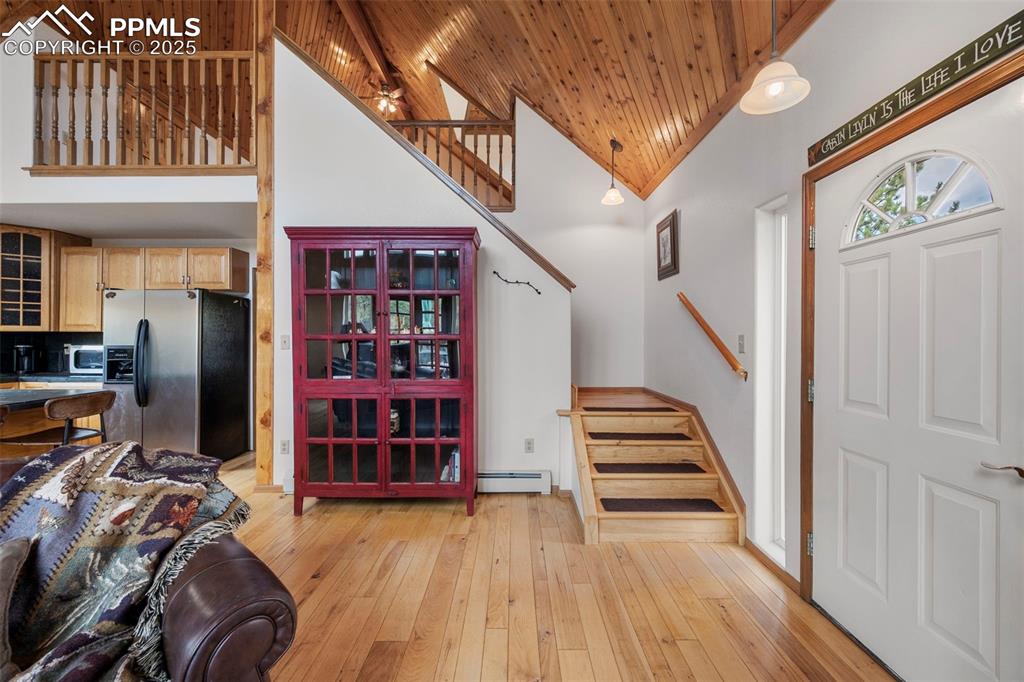 Image 14 of 38: Foyer entrance with stairway, high vaulted ceiling, a ceiling fan, light wo
