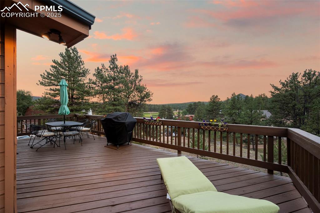 Image 23 of 38: Deck at dusk featuring outdoor dining area and area for grilling