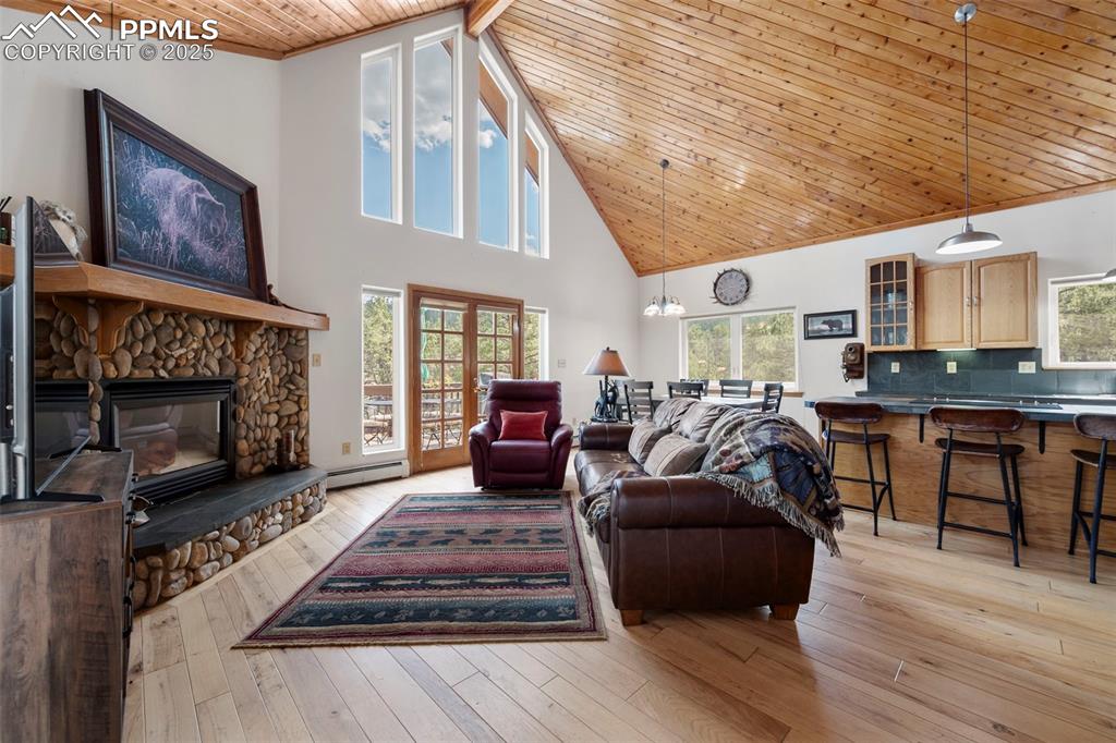 Image 5 of 38: Living room featuring a wood ceiling with exposed beams, high vaulted ceili