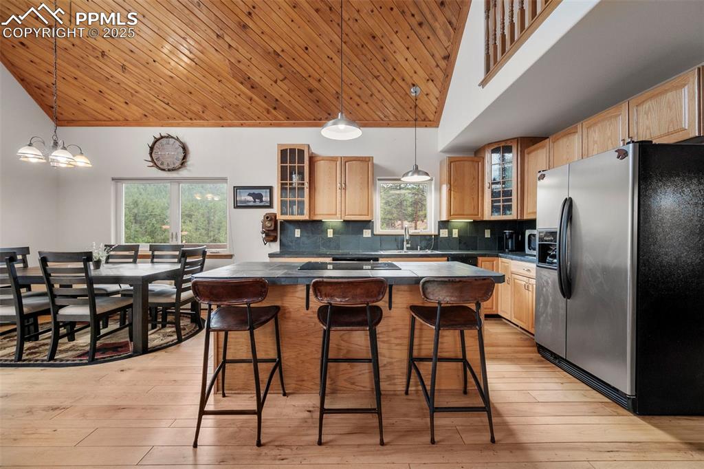 Image 8 of 38: Kitchen with glass insert cabinets, stainless steel refrigerator with ice d