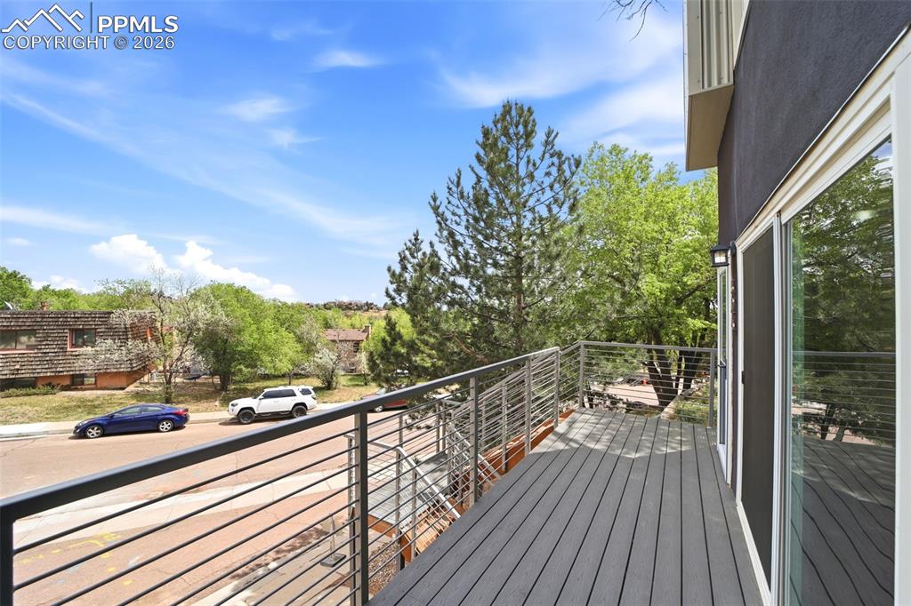 Image 29 of 36: Spacious exterior deck with composite decking, modern cable railings
