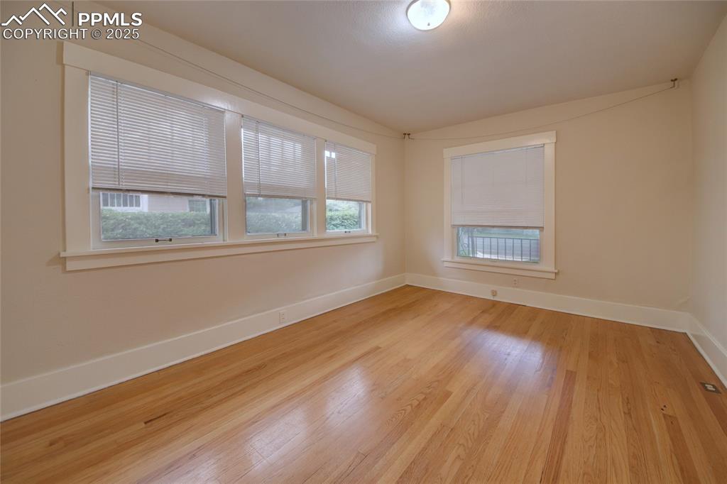 Image 12 of 28: Empty room with light wood-style floors and vaulted ceiling