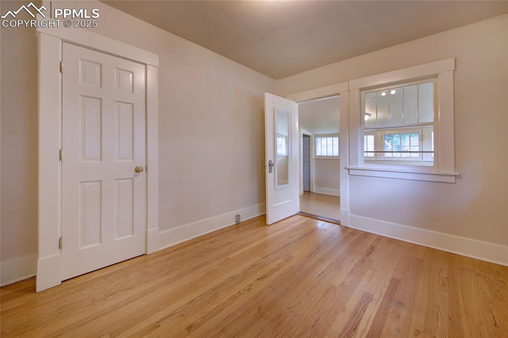 Image 14 of 28: Spare room with baseboards and light wood finished floors