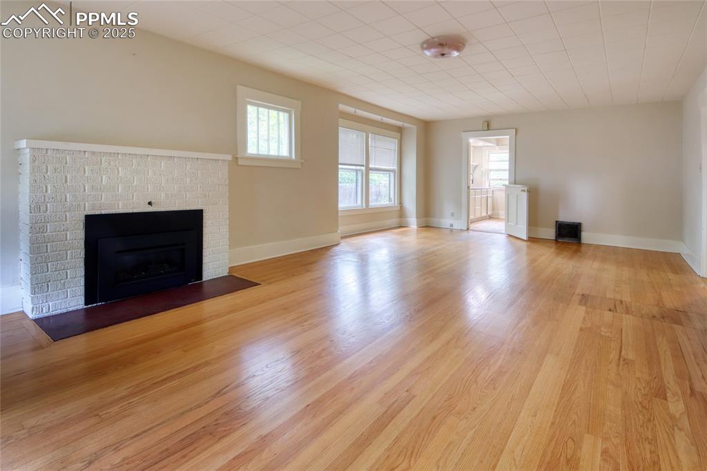 Image 4 of 28: Unfurnished living room featuring a fireplace and light wood-style floors