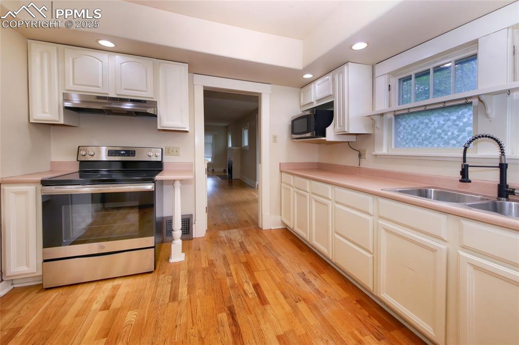 Image 8 of 28: Kitchen featuring appliances with stainless steel finishes, under cabinet r
