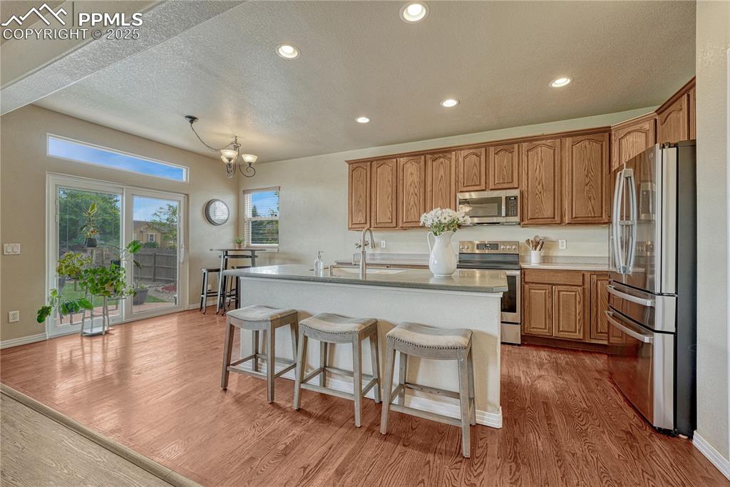 Image 14 of 47: Kitchen with stainless steel appliances, light wood-style flooring, a textu