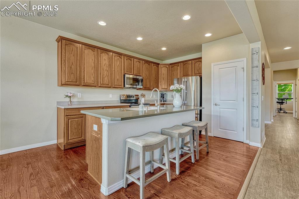 Image 15 of 47: Kitchen featuring recessed lighting, brown cabinets, appliances with stainl