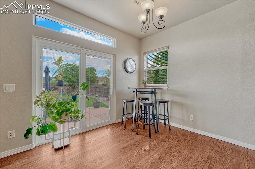 Image 16 of 47: Dining area featuring wood finished floors, a textured wall, and a chandeli