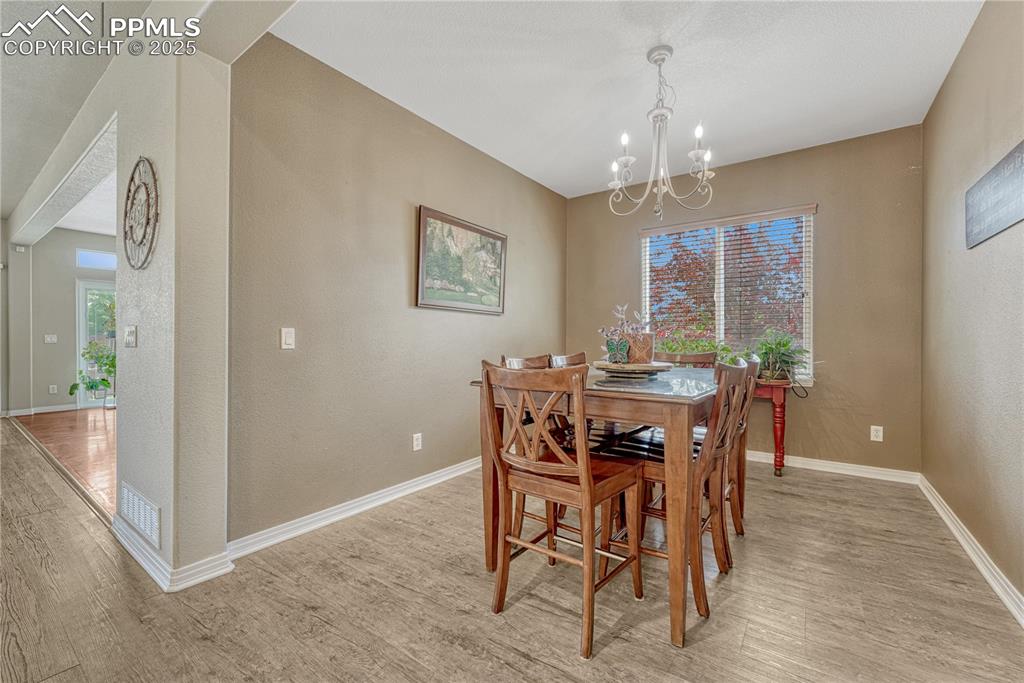 Image 17 of 47: Dining space with light wood-style flooring, a textured wall, healthy amoun