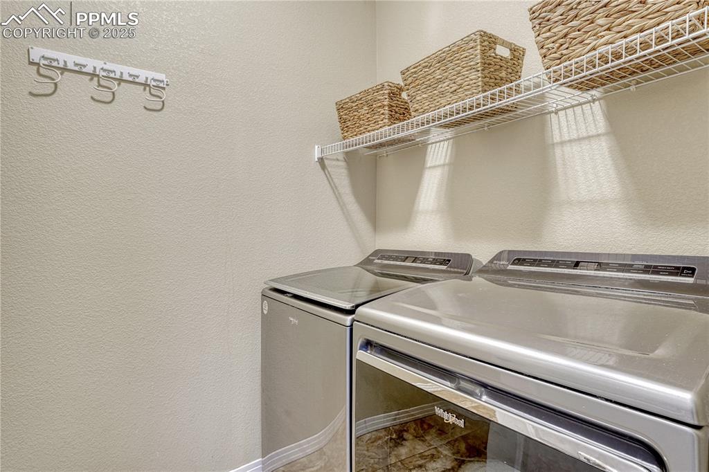 Image 22 of 47: Washroom with a textured wall and separate washer and dryer