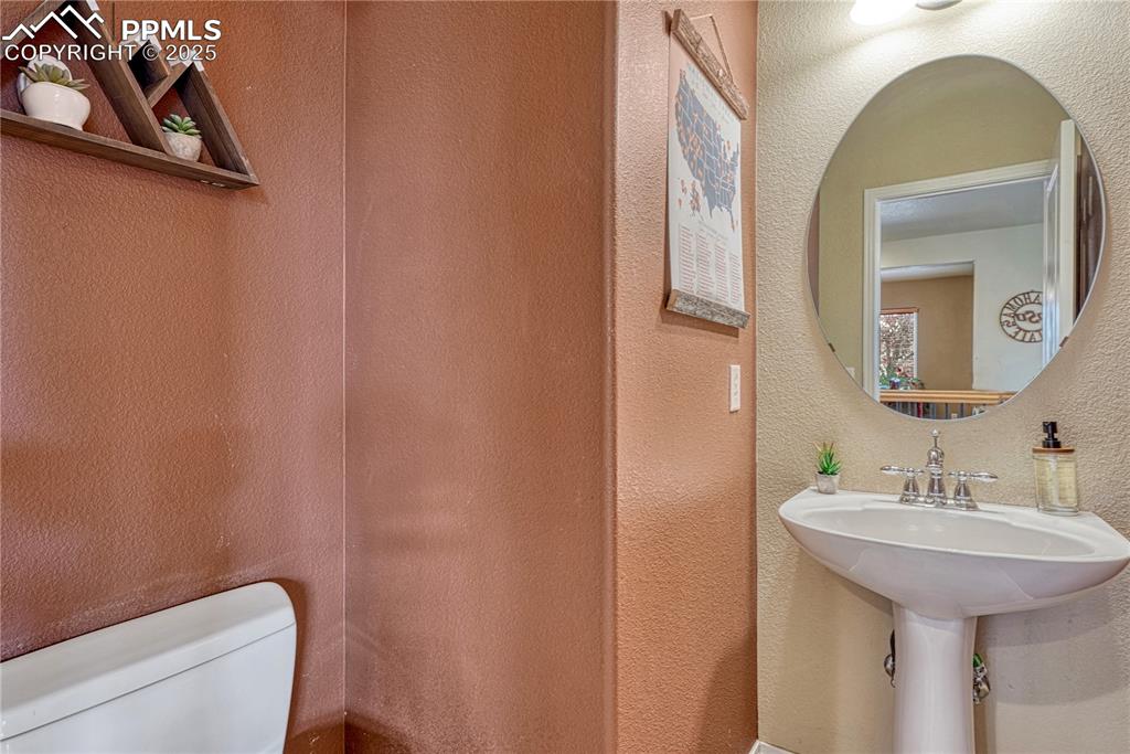 Image 23 of 47: Half bathroom with a textured wall and toilet