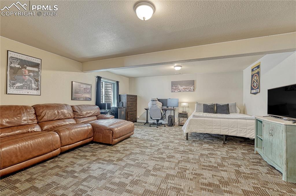 Image 27 of 47: Bedroom with a textured ceiling, carpet floors, and beamed ceiling