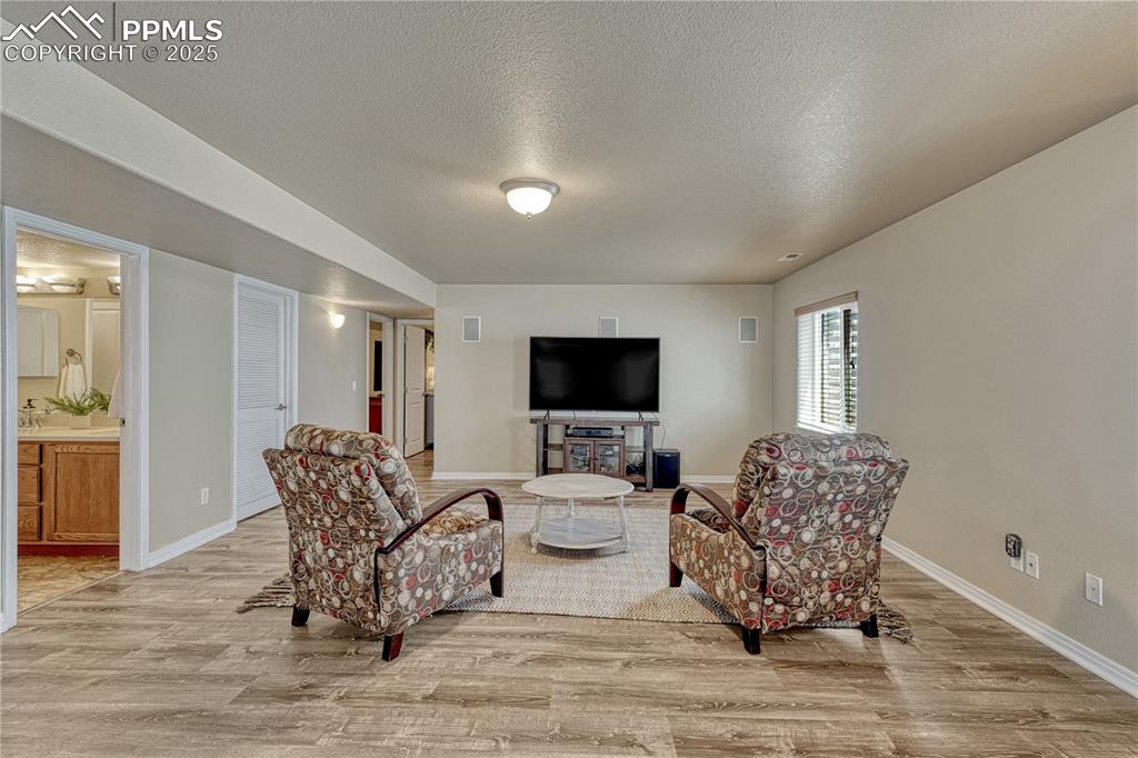 Image 29 of 47: Living area with a textured ceiling and light wood finished floors