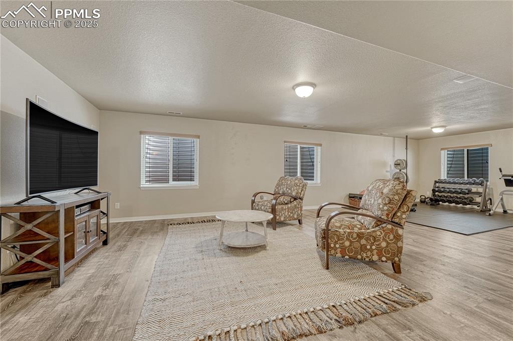 Image 30 of 47: Sitting room with a textured ceiling and light wood finished floors