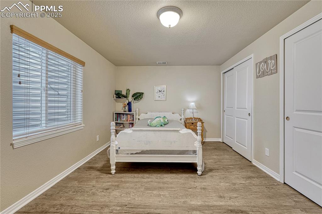 Image 33 of 47: Bedroom featuring a textured ceiling, light wood-type flooring, and a close