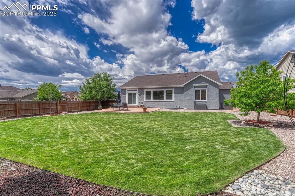 Image 36 of 47: Back of house featuring a patio area, a shingled roof, and entry steps