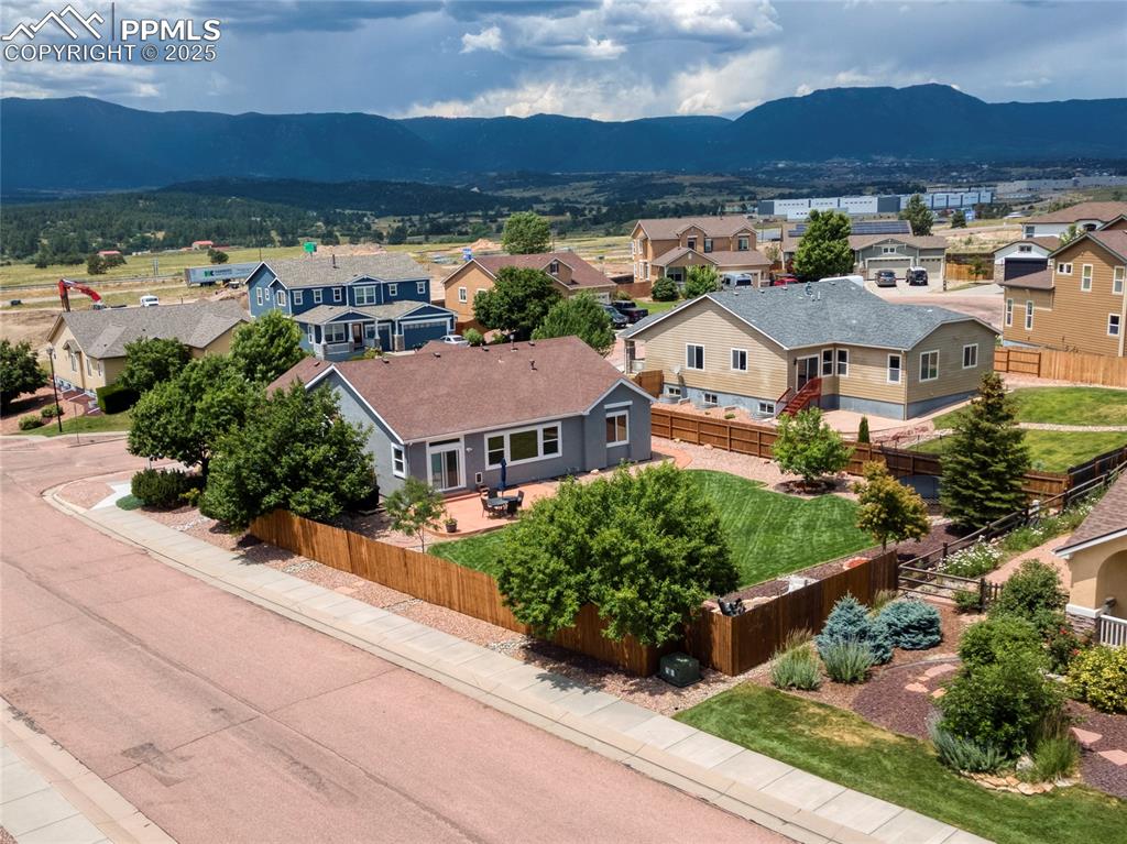 Image 41 of 47: Aerial view of residential area featuring a mountainous background