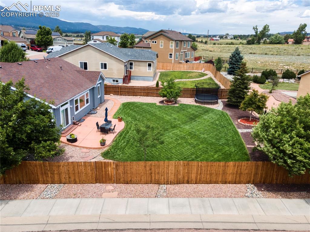 Image 44 of 47: Fenced backyard featuring a patio, an outdoor fire pit, a residential view,