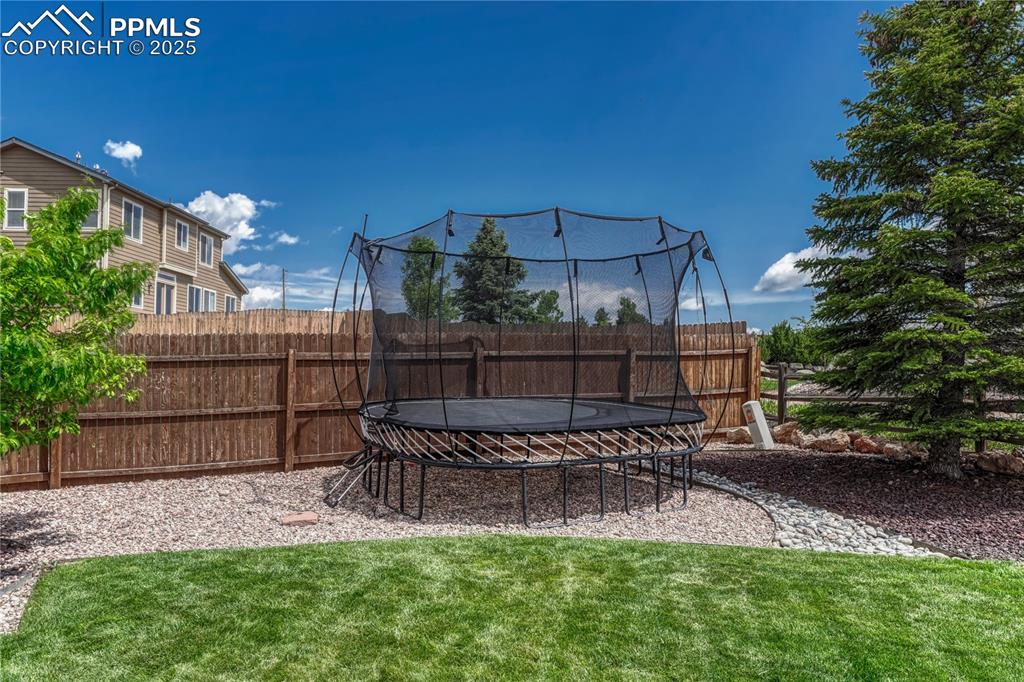 Image 45 of 47: Fenced backyard featuring a trampoline