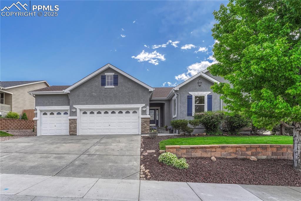 Image 6 of 47: Ranch-style home with stucco siding, driveway, a garage, and stone siding