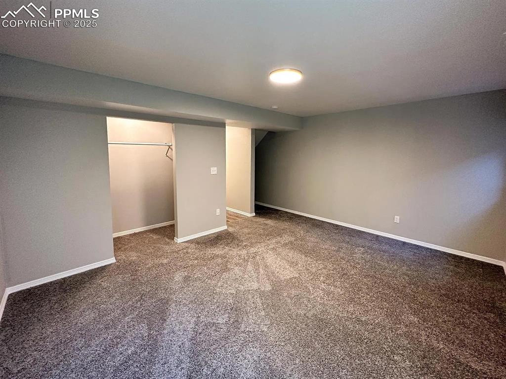 Image 18 of 23: Finished basement with carpet and baseboards