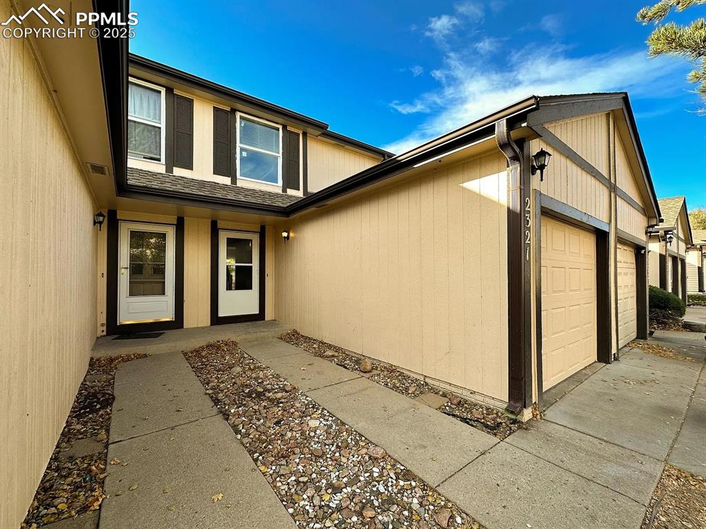 Image 2 of 23: Entrance to property featuring an attached garage and concrete driveway