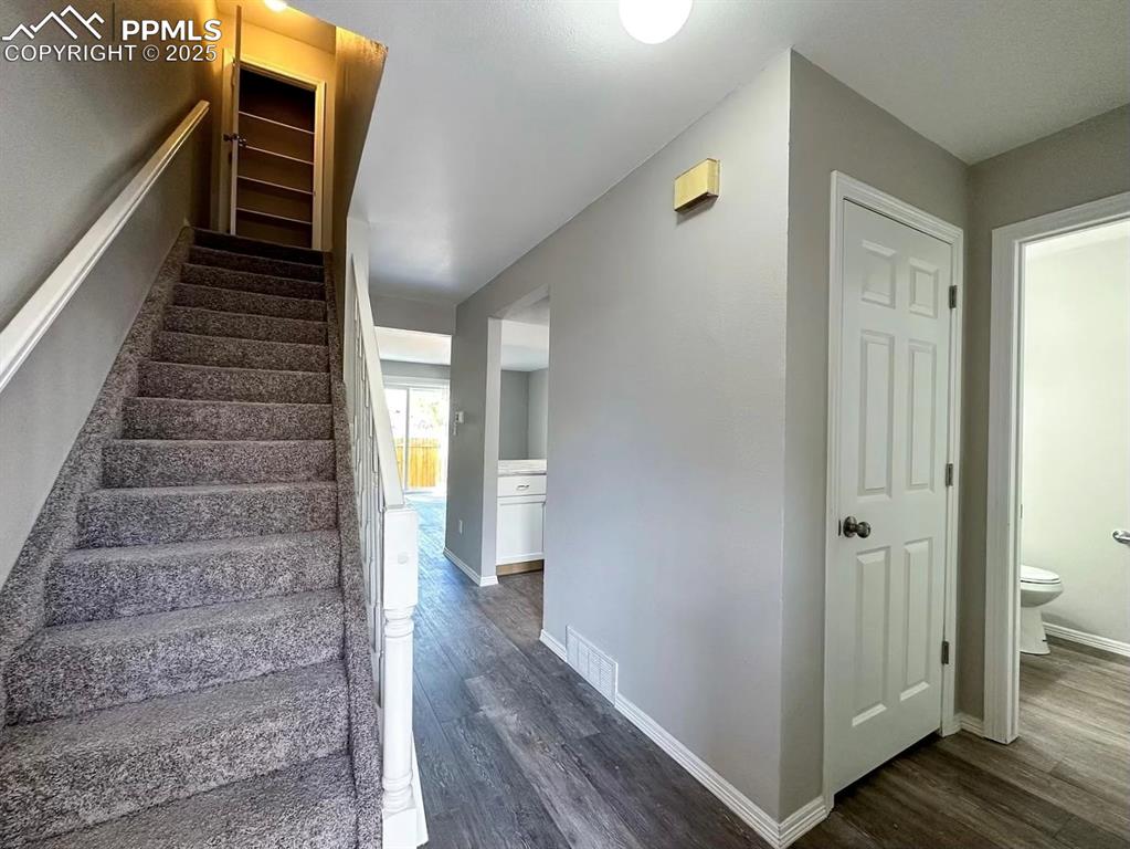 Image 3 of 23: Staircase with wood finished floors, baseboards, and visible vents