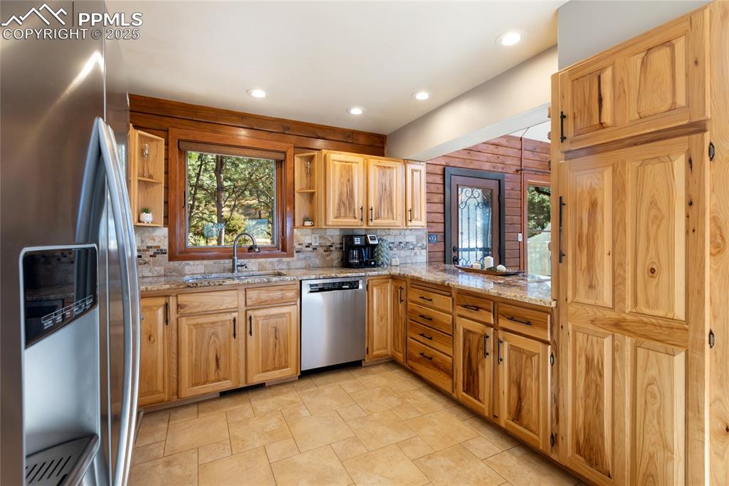 Image 24 of 50: Quartz counters, stainless steel, hickory cabinets, stone accents, open to 