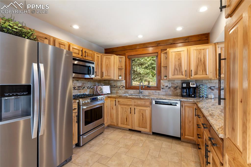 Image 25 of 50: Quartz counters, stainless steel, hickory cabinets, stone accents, open to 