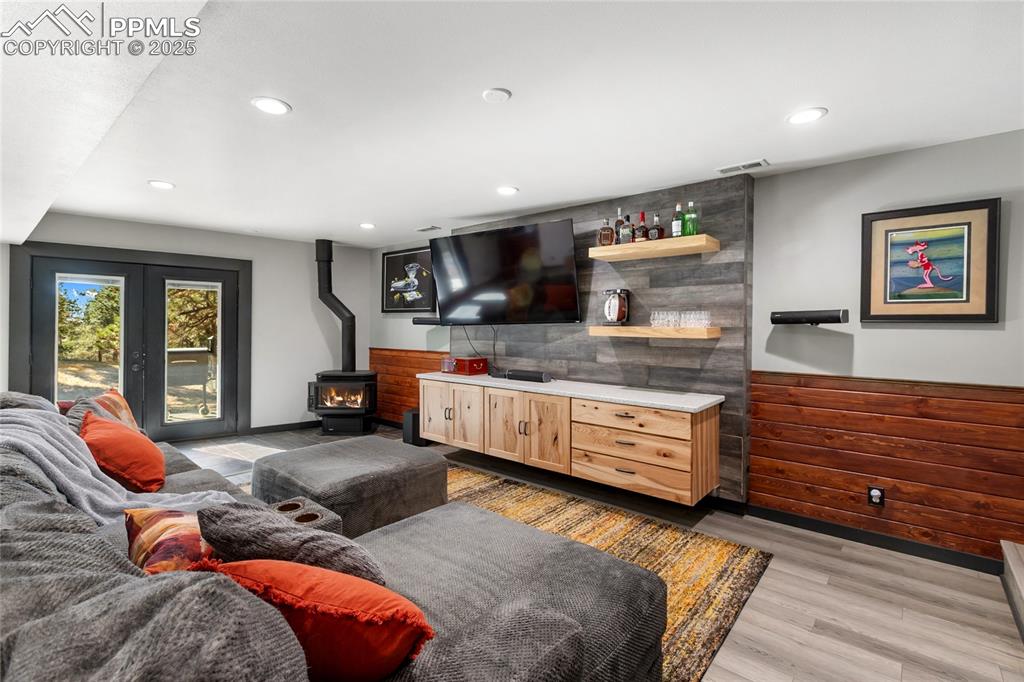 Image 30 of 50: Lower-level walks out, with double sliders, gas fireplace, lvp flooring, an