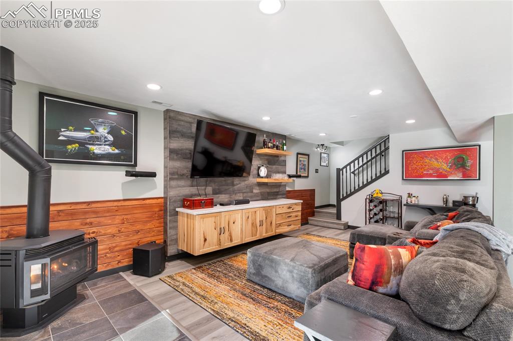 Image 31 of 50: Lower-level walks out, with double sliders, gas fireplace, lvp flooring, an