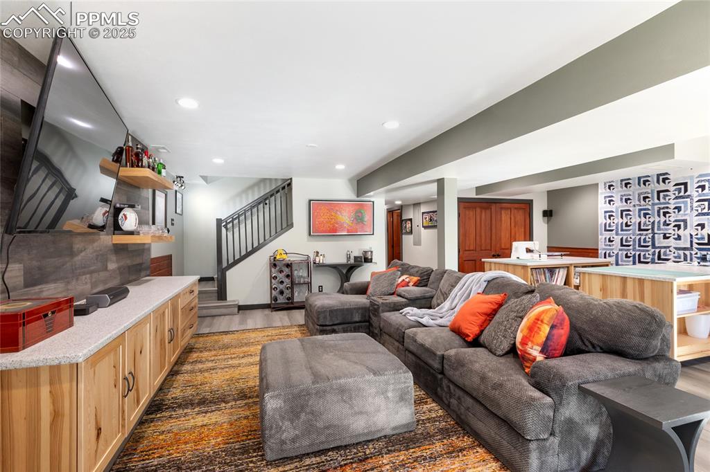 Image 32 of 50: Lower-level walks out, with double sliders, gas fireplace, lvp flooring, an