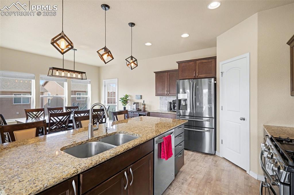 Image 10 of 40: Kitchen featuring a large island with dual stainless steel sinks, a stainle