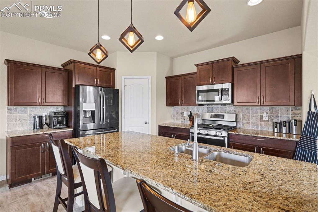 Image 11 of 40: Spacious kitchen featuring an expansive granite-finish island with double b